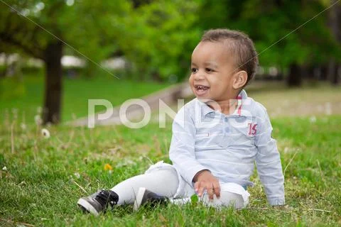 Portrait of a black baby boy playing in the park Stock Photos