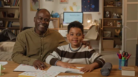 Portrait of Black Dad Helping Son with Elementary School Homework Stock Footage 334965665