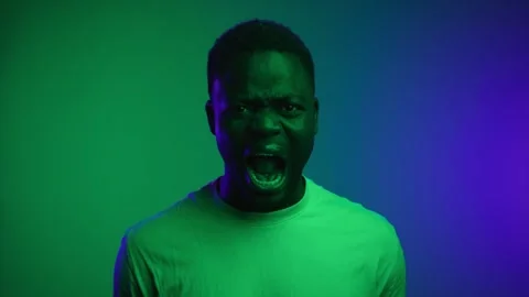 Portrait of Black Man Looking at Camera and Screaming in Neon Lighting of Studio Stock Footage 254460943