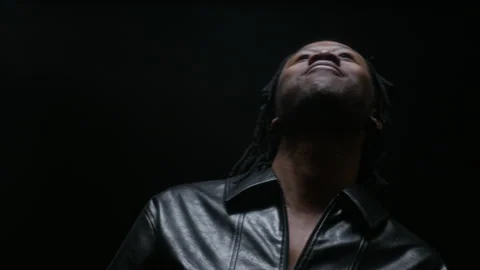 Portrait of Black Man Tossing Candy into Mouth on Black Background Video stock 341393765