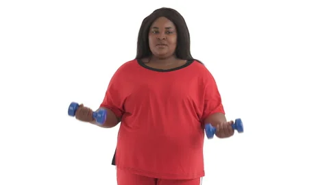 Portrait of black plus size model working hard with dumbbells for weight loss Stock Footage 134571580