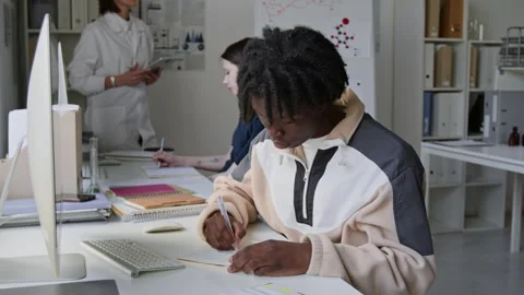 Portrait of Black Student Writing in his Notebook During Chemistry Class in Lab Stock Footage 312319601