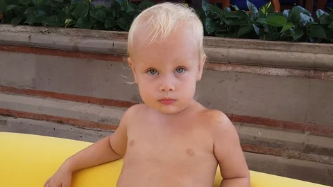 Portrait of a blond cute two year old boy. outdoors, in summer. Stock Footage 109534660