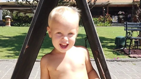  Portrait of a blond joyful two-year-old boy. on the street in summer. Stock Footage 109534643