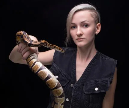 Portrait of blond woman holding python Stock-Fotos