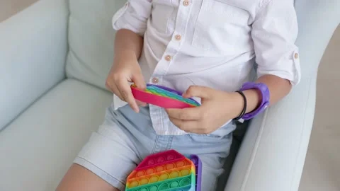 Portrait blonde boy with pop it sensory toy different forms. Stock-Footage 156867115