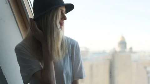 Portrait of a blonde in a hat by the window Stock Footage 144567216