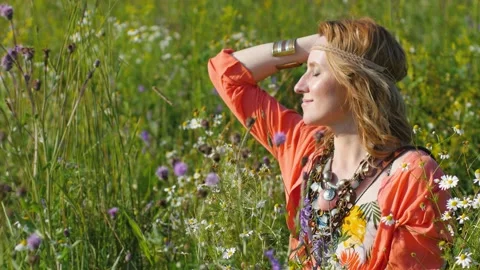 Portrait of blonde hippie dancing in a field with flowers. Woman in boho style Stock-Footage 151663502