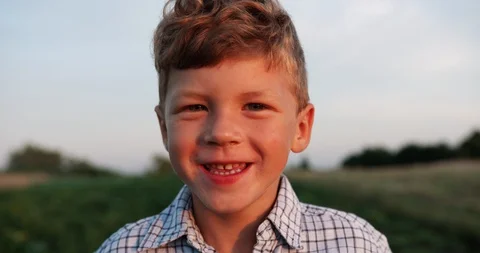 Portrait of blonde little boy posing outside and laughs. Stock Footage 128049869