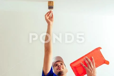 Portrait from bottom of painter while painting the wall Stock Photos