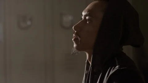 Portrait of boxer sitting on bench looking up focused in musty locker room 스톡 동영상 104545052