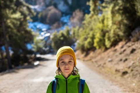 Portrait of a boy with a backpack in the forest. The child is standing in the Stock Photos