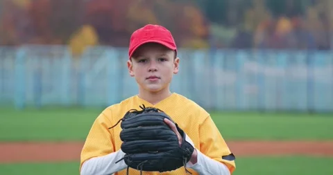Portrait of a boy baseball player on a blurry background, the pitcher holds the Stock Footage 252643946