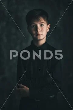Portrait of a boy in black clothes on a black background in the Studio. Child Stock Photos