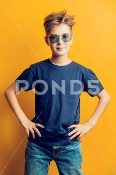 Portrait of a boy in casual clothes on a yellow background in the Studio. Chi Stock Photos