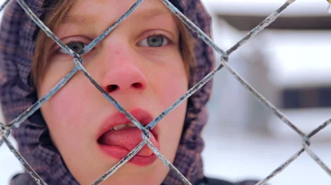 Portrait of a boy, close-up through the bars of the fence. Stock Footage 46532088