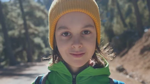 Portrait of a boy in the forest. The child is standing in the middle of the road Stock Footage 239994020