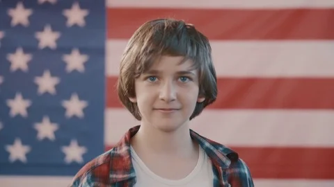 Portrait of a boy in front of american flag. shot in slow motion Stock Footage 75780189
