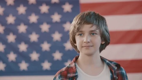 Portrait of a boy in front of american flag. shot in slow motion Stock Footage 75780348
