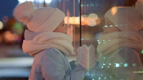Portrait Boy with Gifts box looking and dreaming in Christmas window shopping on Stock Footage