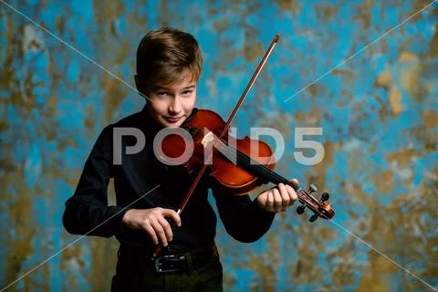 A portrait of a boy in his teens playing the violin. A creative, talented, gi Stock Photos