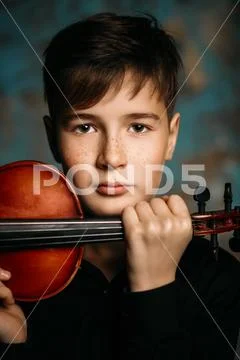 A portrait of a boy in his teens playing the violin. A creative, talented, gi Stock Photos