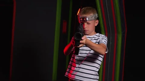 Portrait of a boy with laser guns, having fun on a dark laser tag arena. Stock Footage 321814311