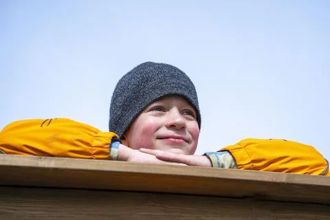 Portrait boy in an orange jacket . the boy looks into the distance Stock-Fotos