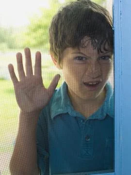 Portrait of a boy peeping through a window Foto stock