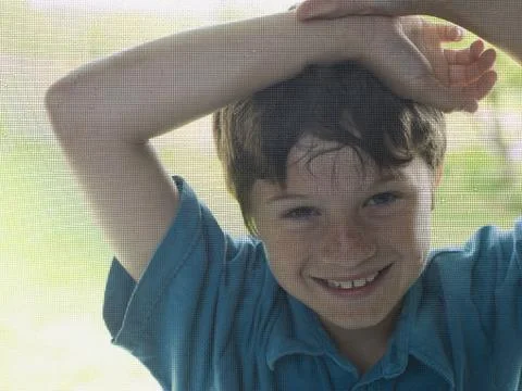 Portrait of a boy peeping through a window Stock Photos