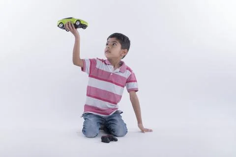 Portrait of a boy playing with remote control car - studio shot isolated on w... Stock Photos