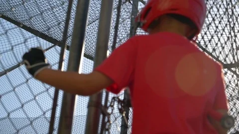 A portrait of a boy practicing little league baseball at the batting cages, slow Stock Footage