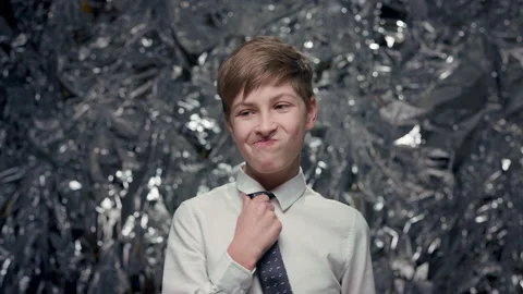 Portrait Of Boy On Shiny Surface. He Shows Surprise And Touches His Tie. His Stock Footage 181547200