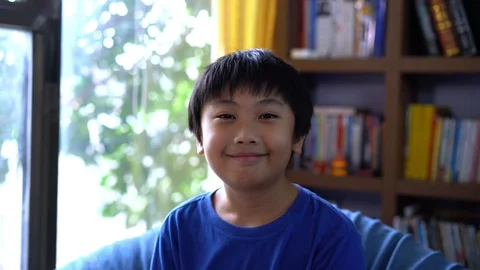Portrait boy smiling and sitting at home Stock Footage 129484027