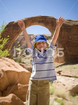 Portrait of a boy standing with his arms raised Stock Photos