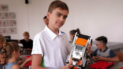 Portrait of a boy student in robotics office at school with robot in her hands. Stockbeeldmateriaal 142079043