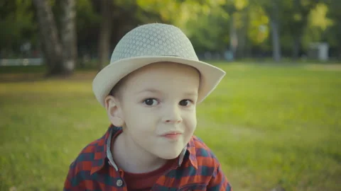 Portrait of a boy of two years in a hat and shirt in the park. Stock Footage 91321217