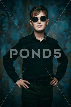 A portrait of a boy wearing classic clothes and sunglasses. Beauty, fashion, Stock Photos