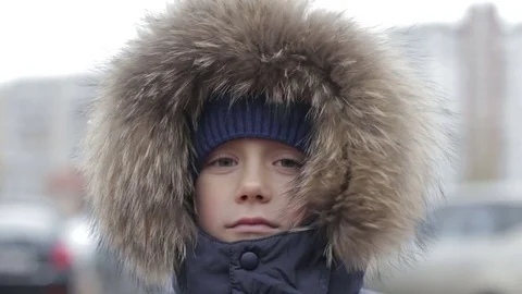 Portrait of a boy in winter jacket with hood on his head Stock Footage 69748235