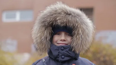 Portrait of a boy in winter jacket with hood on his head Stock Footage 72205645