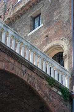 Portrait of a brickwork arch bridge between two buildings in a Tuscan town Stock Photos