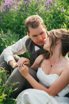 Portrait of the bride and groom resting on a lavender background Stock Photos