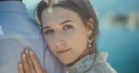 Portrait of the bride looking at camera and groom hugging her in old town Stock Footage 137906535