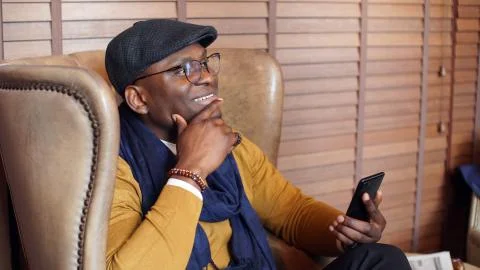 Portrait of a brooding African-American man with glasses sitting in a restaurant Stock Photos