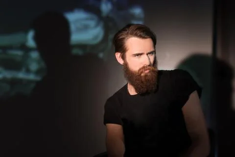 Portrait of brooding bearded man biker sitting in a chair Stock Photos