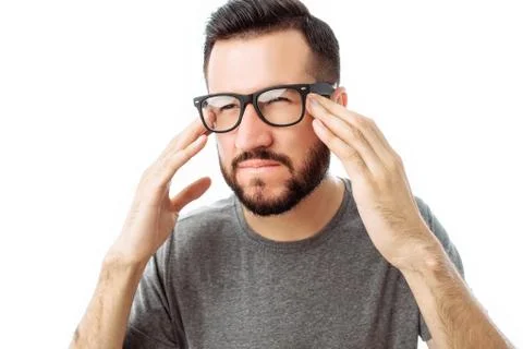 Portrait of brooding bearded man in grey t-shirt looking up and putting hand  Stock Photos