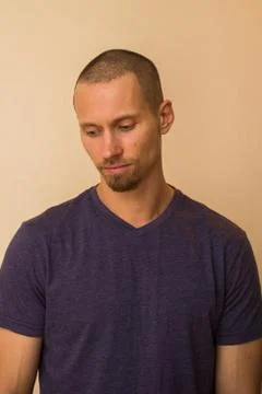 Portrait of a brooding young man in a blue or purple photoball against a beige Stock Photos