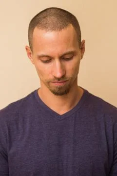 Portrait of a brooding young man in a blue or purple photoball against a beige Stock Photos