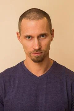Portrait of a brooding young man in a blue or purple photoball against a beige Stock Photos