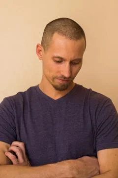 Portrait of a brooding young man in a blue or purple photoball against a beige Stock Photos